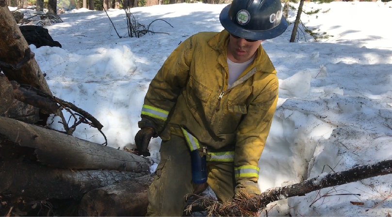 Andrew-Looy-Video-Cover-2 Corpsmembers with the Placer 1 fire crew cut fire line with hand tools as flames from the Dixie Fire approach in 2021.