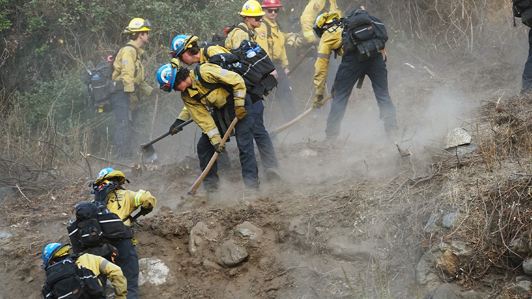 Wildland firefighting Corpsmembers work together to build a fire break, during emergency response.