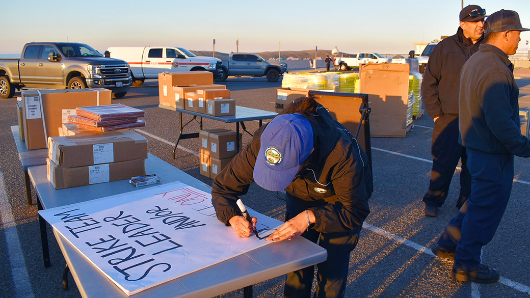 Emergency_Pomona_PalisadesCampSign_010925_1040x585 female making sign on table in parking lot