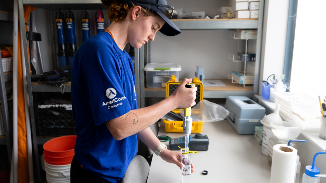 CCC WSP Corpsmember Shannon Swan draws a water sample at a lab in Morro Bay.